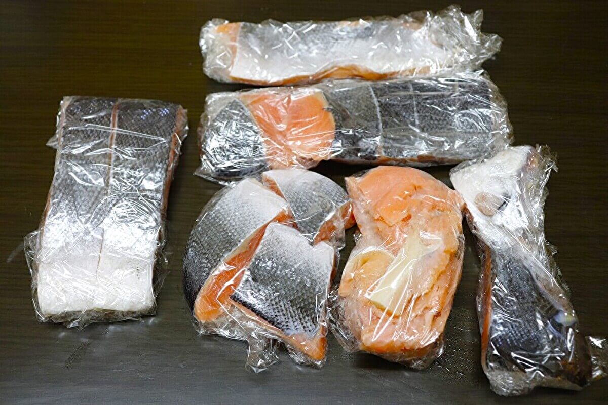 業務スーパー「塩鮭フィレ」を切り分けてラップで包んだ画像