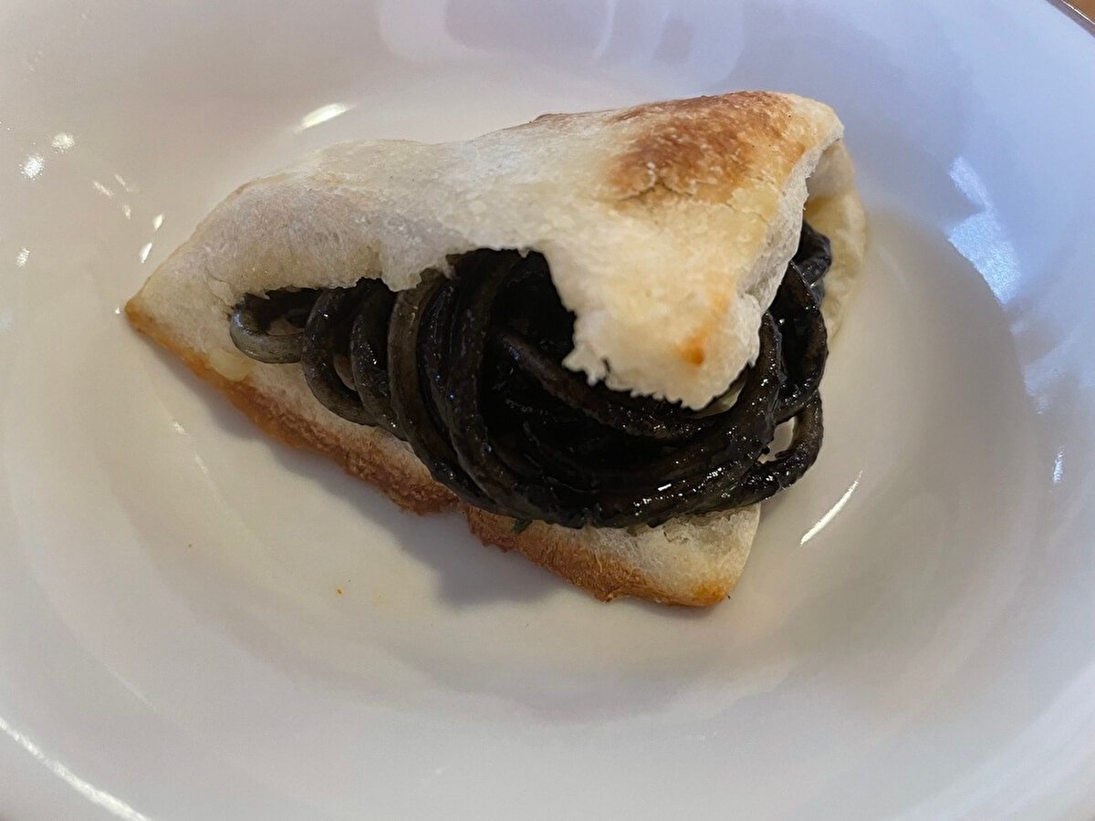 プチフォッカにイカの墨入りスパゲッティを挟んだ画像